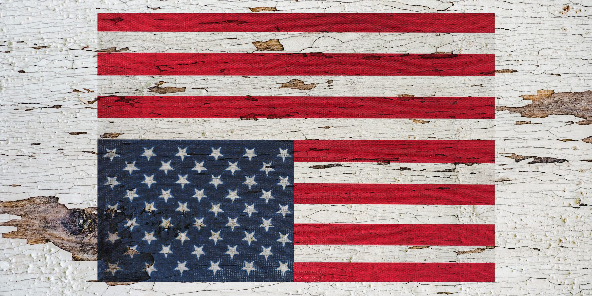 Picture of an upside down America flag painted on the side of a barn or other structure.
